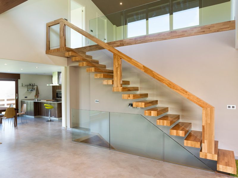 Escalera diseño de un tramo realizada en madera de roble con pasamanos de vidrio y madera